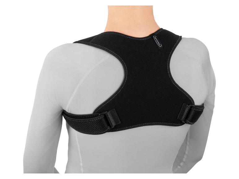 Achteraanzicht van een persoon die een zwarte Sensiplast houdingcorrector draagt over een wit shirt met lange mouwen