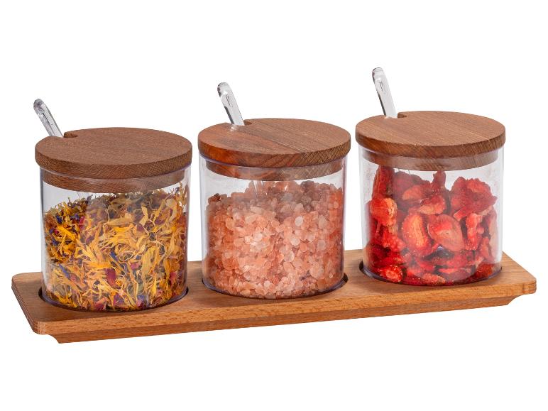 Kruiden, roze Himalayazout en gevriesdroogde aardbeien in glazen potten met houten deksels.