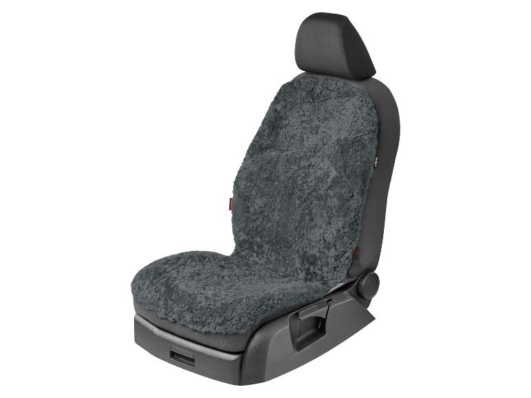 Donkergrijze schapenvacht autostoelhoes op een zwarte autostoel.