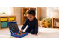 Lachende jongen speelt met magnetische letters op een tapijt in een kinderkamer.