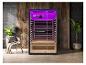 Moderne sauna met paarse verlichting, een relaxstoel en planten.