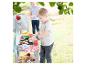 Kinderen spelen buiten met een speelgoedbarbecue en vilten eten.