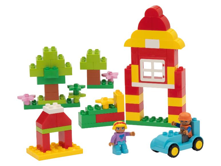 Bouwset met kleurrijke blokken, inclusief een huis, bomen, een auto en twee figuren.