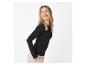 Blonde vrouw in een zwarte top met lange mouwen en beige broek, lachend en opzij kijkend.