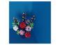 Een levendig boeket kleurrijke kunstbloemen in een vaas tegen een blauwe achtergrond.
