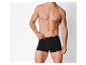 Een man toont zwarte boxershorts.