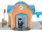 Speelgoedtreinstation met klok, draaideur en een machinistfiguur.