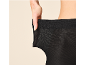 Vrouw toont de elasticiteit van een zwarte panty.