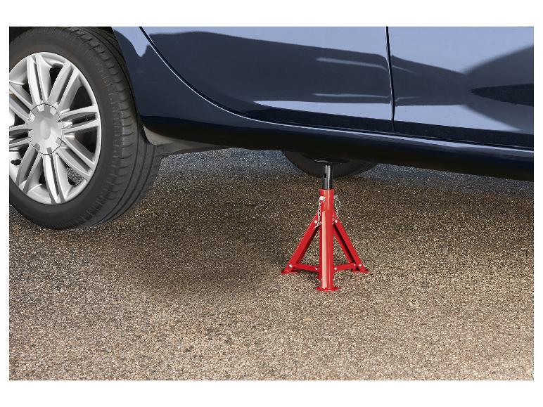 Auto op een rode assteun op asfalt.