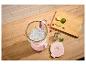 Roze blender met ijs, limoenen, frambozen en munt op een houten tafel.