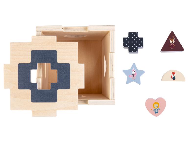 Een houten doos met geometrische vormen, een kruis met stippen, een ster met een eenhoorn en een hart met een leeuw.