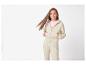 Tienermeisje in beige hoodie met rits en bijpassende joggingbroek.