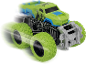 Groene monster truck speelgoedauto in beweging op een zwarte achtergrond.