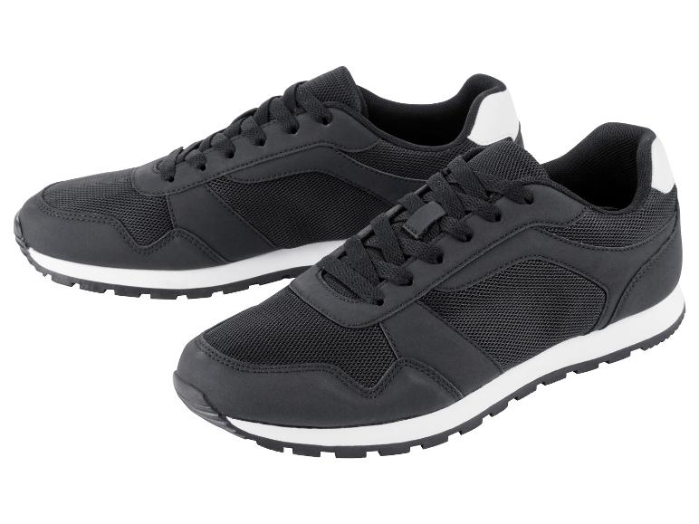 Twee zwarte sneakers met witte zolen.