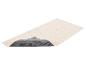 Een beige badmat met de zichtbare antislip onderkant.