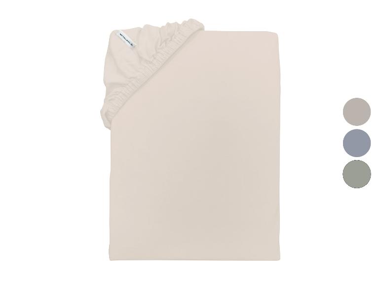 Lichtbeige hoeslaken met elastiek en kleurstalen in grijs, blauw en groen.