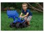Jongen met blauwe speelgoedgraafmachine speelt op het gras.