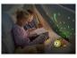 Twee kinderen lezen een boek in een tent met een schildpad nachtlampje dat sterren projecteert.