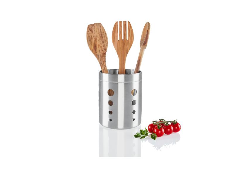 Houten keukengerei in een stalen houder met tomaten.