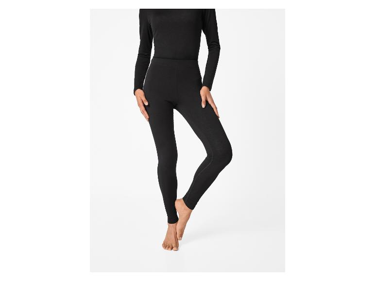 Een persoon draagt een zwart shirt met lange mouwen en een zwarte legging.