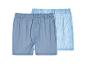 Twee heren boxershorts: één effen blauw en één blauw met witte strepen.