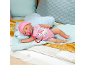 Slapende babypop met roze muts en romper met eenhoornmotief, met speen.