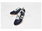 Blauwe sneakers met witte strepen en bruine rubberen zool