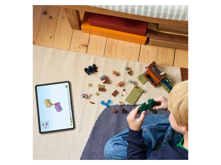 Kind bouwt LEGO Minecraft met digitale instructies op een tablet.