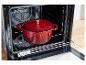 Een rode Silvercrest gietijzeren pot in een oven.