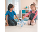 Twee kinderen spelen met een wit-blauwe robotpuppy op de vloer.