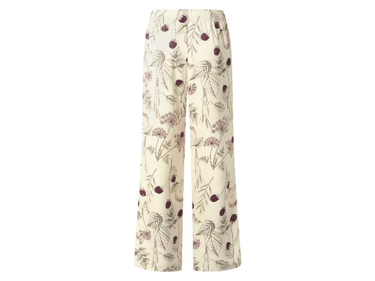 Wijde broek met bloemen- en bessenpatroon op een crèmekleurige achtergrond.