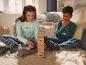 Twee kinderen in pyjama's spelen Jenga.