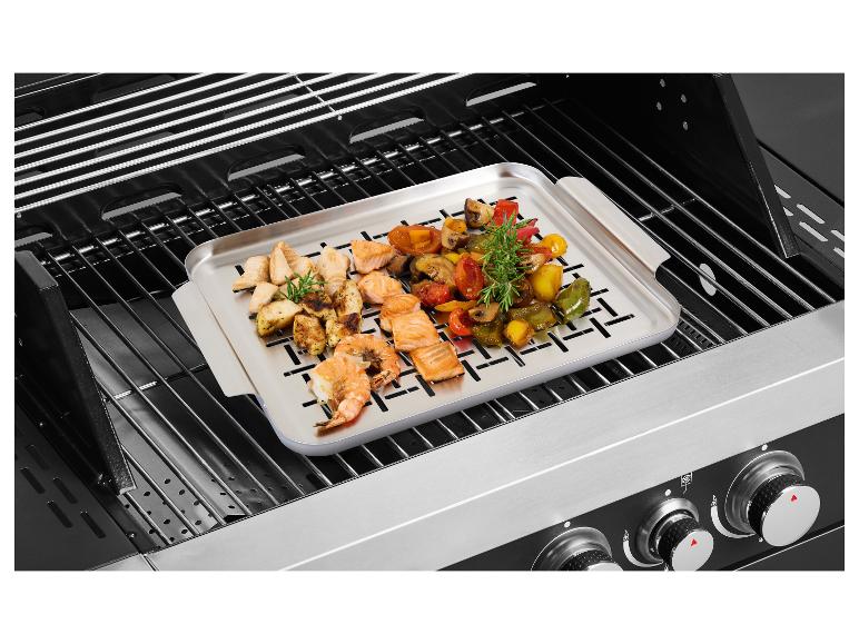 Grill met een schaal gegrilde groenten, kip, zalm en garnalen.