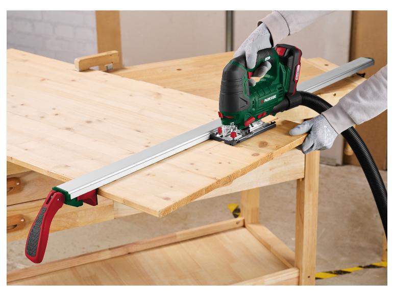 Persoon zaagt hout met een Parkside decoupeerzaag en zaaggeleider op een werkbank.