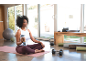Vrouw ontspant na training met draagbare blender, naast dumbbells en yogamatten.