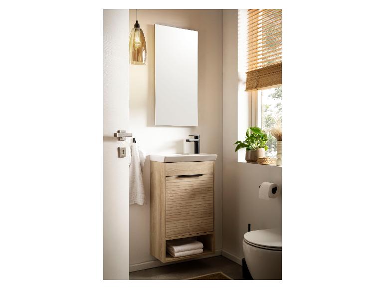 Moderne badkamer met houten wastafelmeubel, spiegel en toilet.