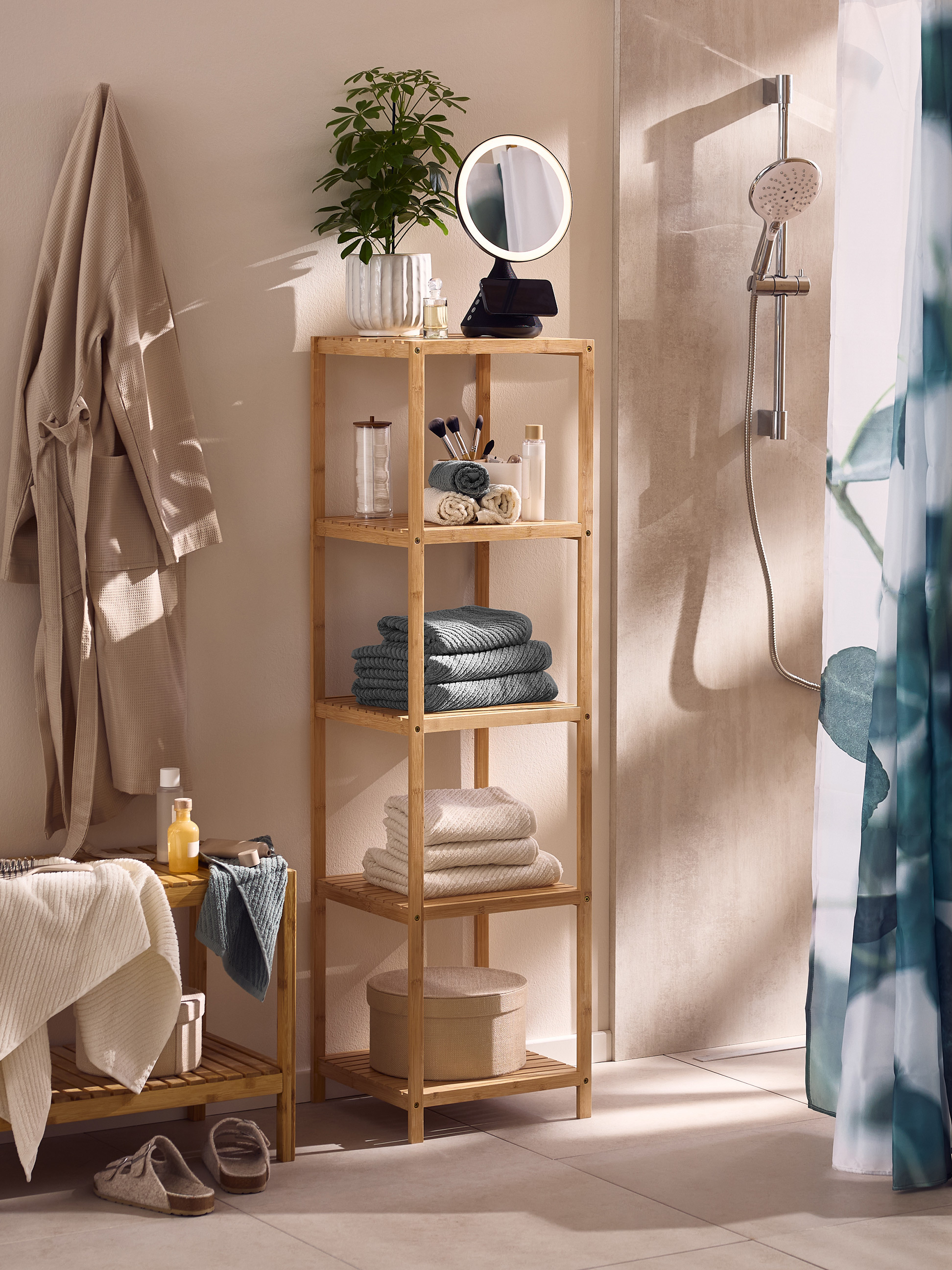 Badkamer met bamboe rek, badjassen, handdoeken en douche.