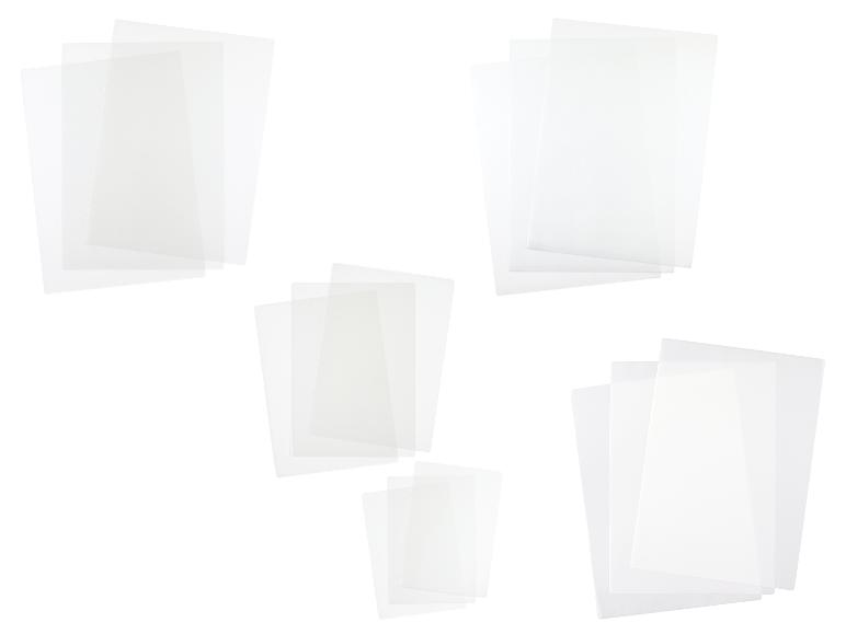 Meerdere stapels transparante plastic vellen of documenthoezen op een witte achtergrond.
