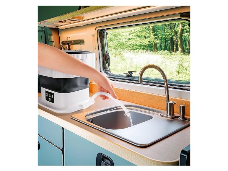 Draagbare wasmachine die water afvoert in een gootsteen in een camper.