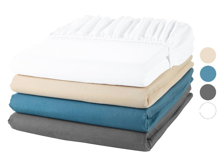 Stapel hoeslakens: wit, beige, teal en grijs.