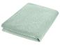 Opgevouwen lichtgroene deken, zacht en pluizig.
