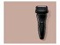 Zwart elektrisch scheerapparaat op een roze-beige achtergrond.