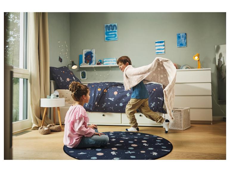 Twee kinderen spelen in een slaapkamer met ruimtethema, met een tapijt en een deken.