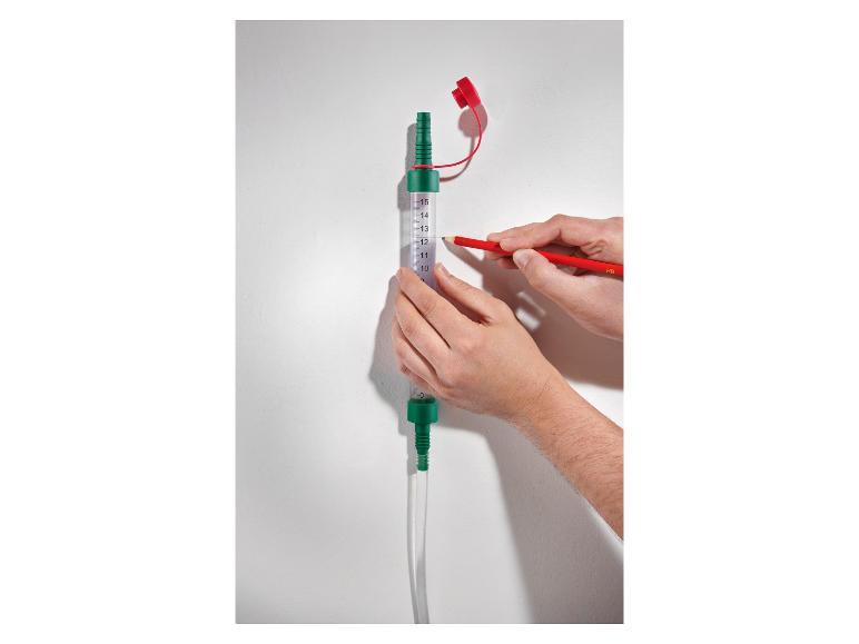 Een hand die een watermeter gebruikt om de hoogte van een muur te markeren met een potlood.