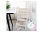 ROBA Treppenhochstuhl Sit Up: beige kinderstoel met veiligheidsgordels, naast een tafel met kinderservies en speelgoed.