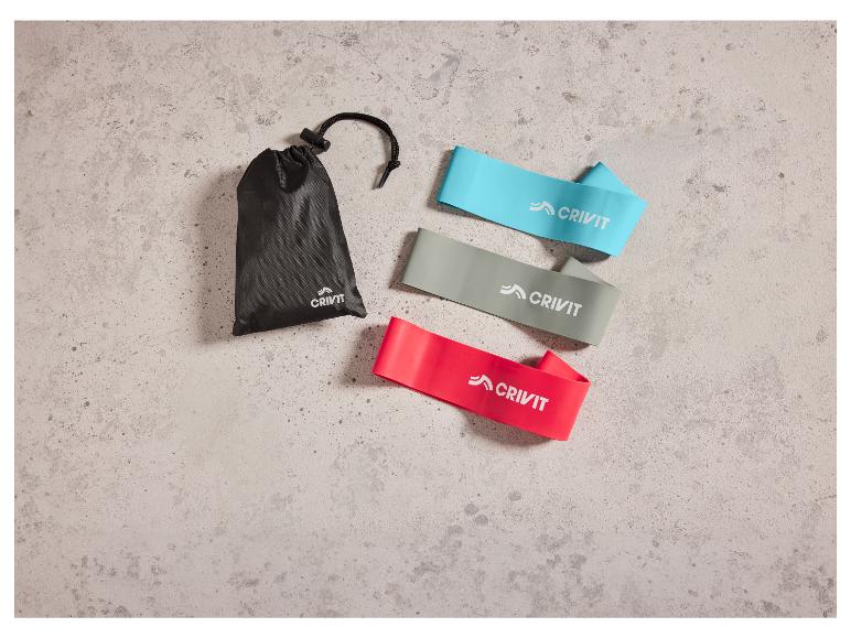 Drie Crivit fitness elastieken in verschillende kleuren met een zwarte opbergtas.