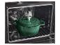 Groene gietijzeren braadpan in een oven op een rooster