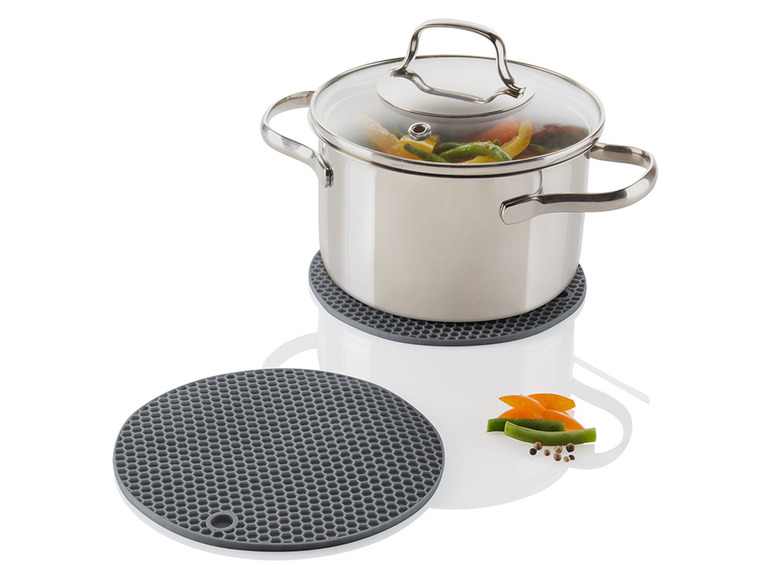Een kookpan met deksel op een grijze siliconen onderzetter.