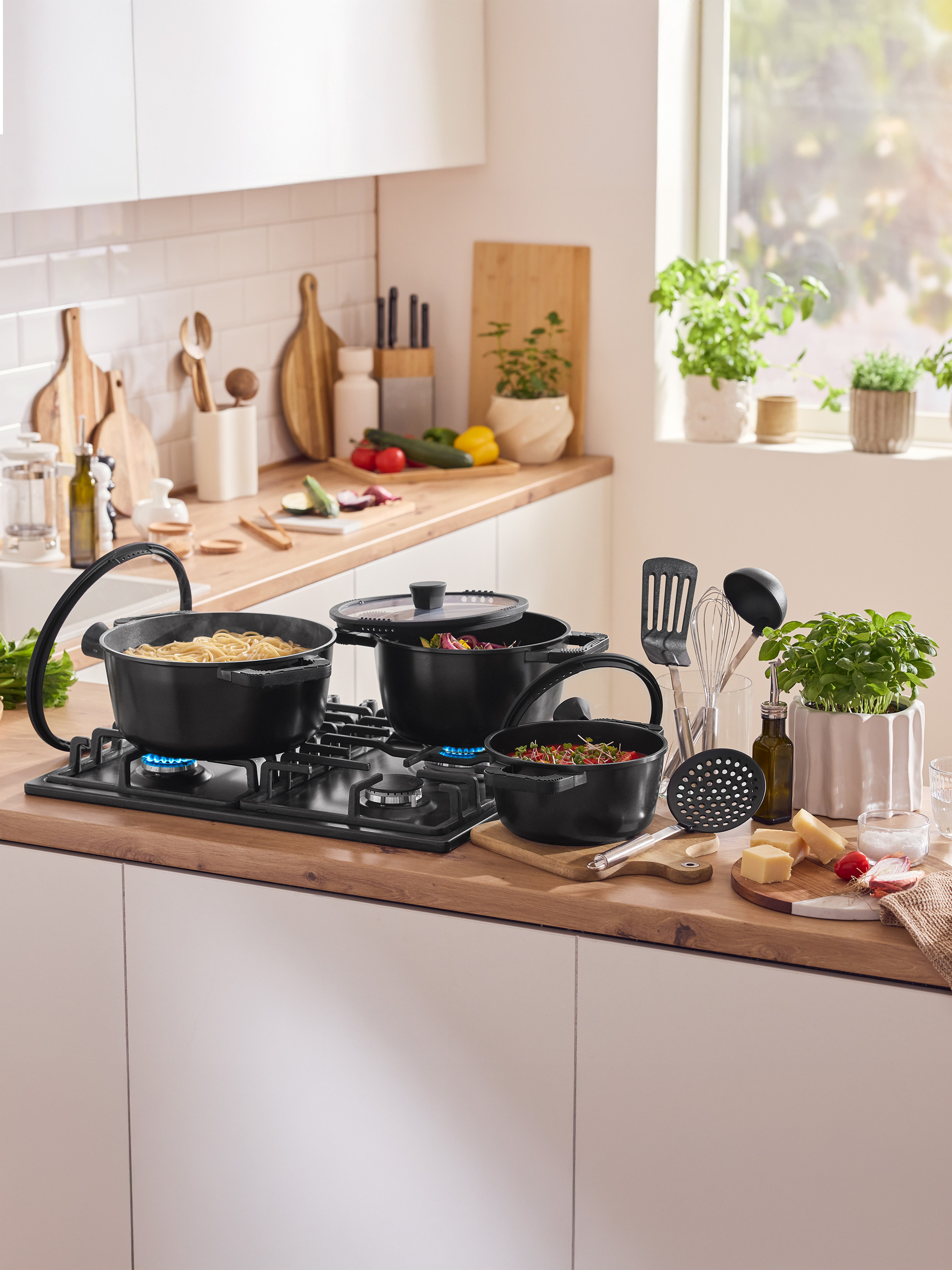 Aanrecht met pannen op het fornuis, keukengerei en verse ingrediënten.