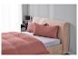 Bed met terracotta beddengoed en kussens.